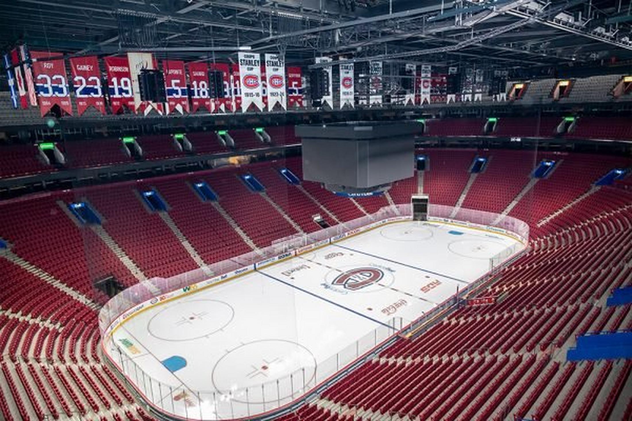 a hockey rink with red seats and a scoreboard